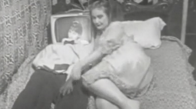 Breathdeath A woman lies in bed next to a man with a TV for a head