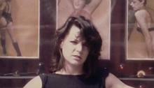 Punk woman standing in front of a movie poster