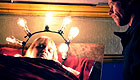 Sick woman lying in bed with a halo of light bulbs