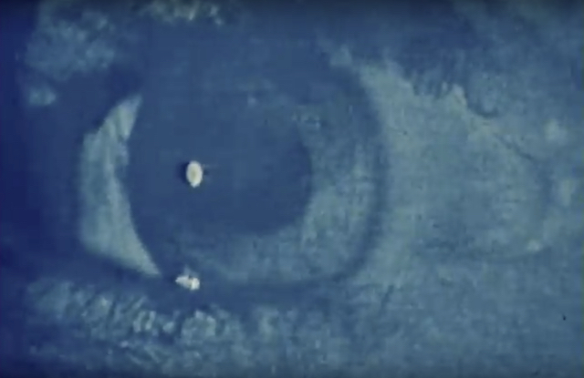 Film still featuring a blue eyeball from the short film Offon by Scott Bartlett