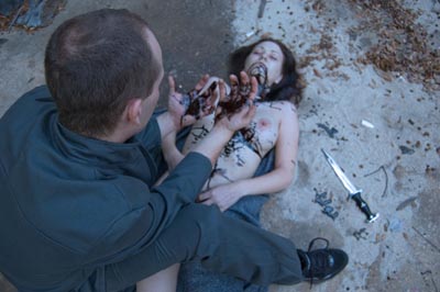 Disturbed man with bloody hands standing over a woman's body