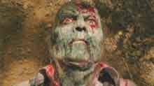 Green-faced zombie covered in blood
