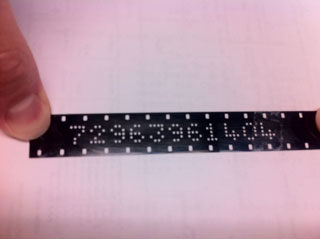 16mm film strip with batch and emulsion numbers punched into it