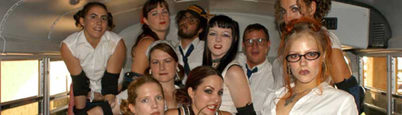 Roller derby team posing in a school bus