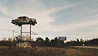Car hoisted on a pole at a roadside attraction