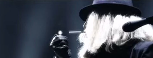 Performer on stage lighting a cigarette