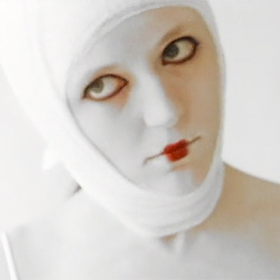 Woman with bizarre white makeup and bandages wrapped around her head