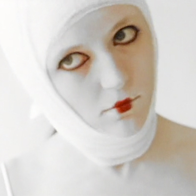 Woman with bizarre white makeup and bandages wrapped around her head