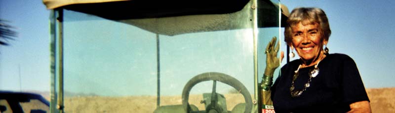 Petre Melvin stands next to a golf cart in the California desert