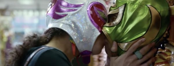 Two women wearing Mexican wrestler masks make-out