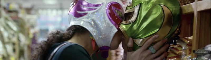 Two women wearing Mexican wrestler masks make-out