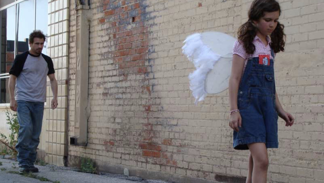 Endings, A Movie By Chris Hansen Film still from the movie Endings featuring a young girl wearing angel wings