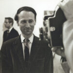 Jonas Mekas in an art gallery watching Marie Menken filming